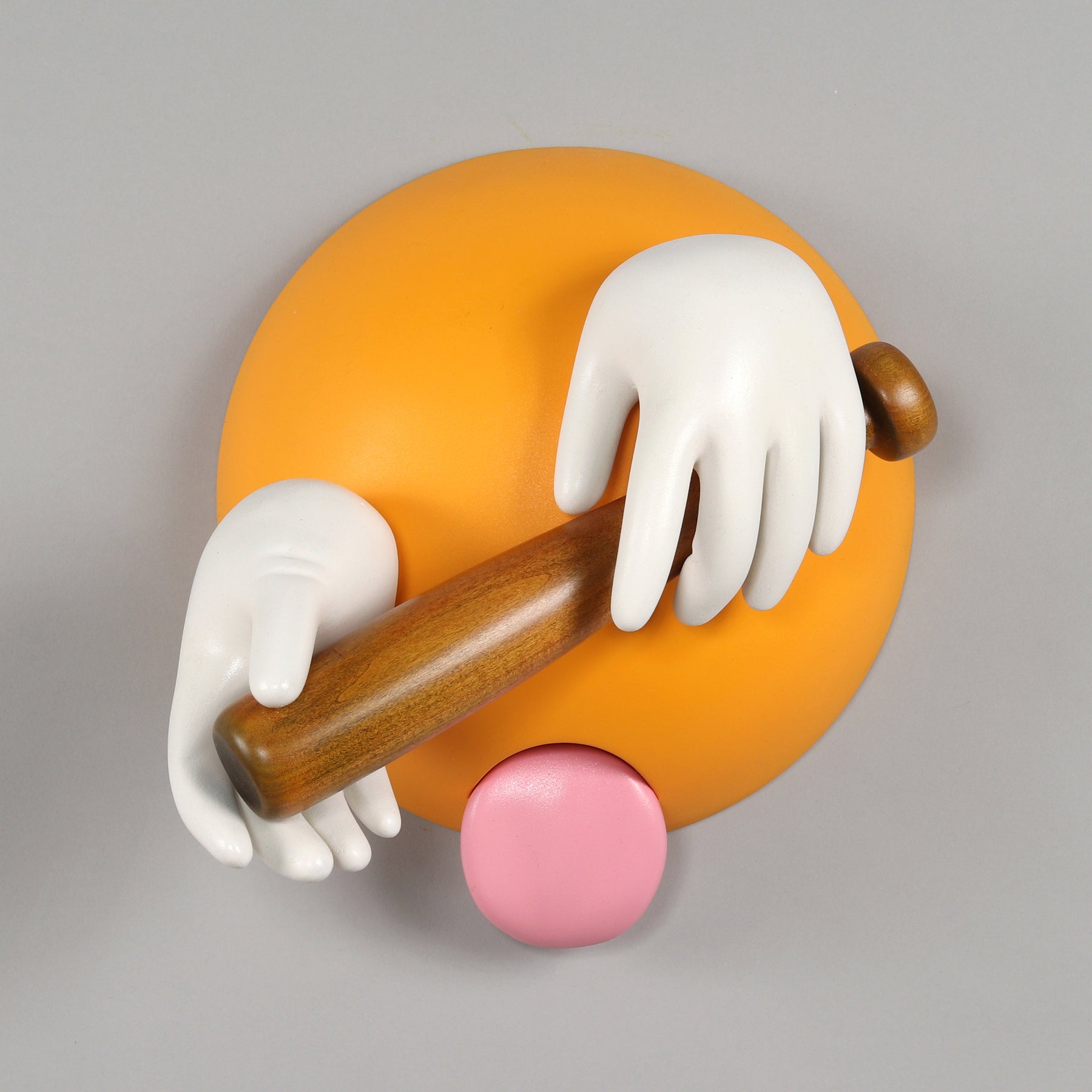 Sculpture of an emoji with hands holding a baseball bat and sticking out its tongue by Gale Hart.