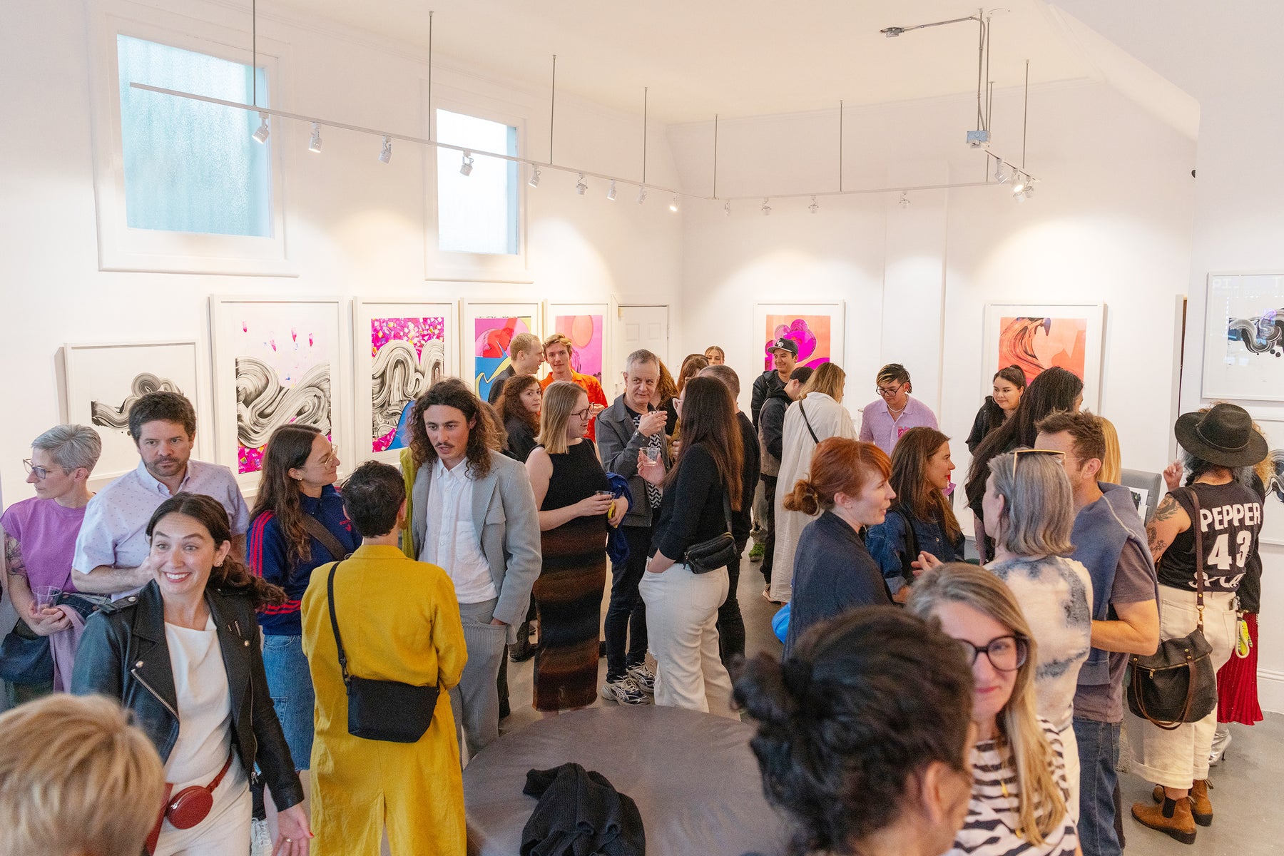 Photograph of a lively crowd joyously celebrating an opening reception at Voss Gallery in San Francisco, with attendees mingling and enjoying the event.